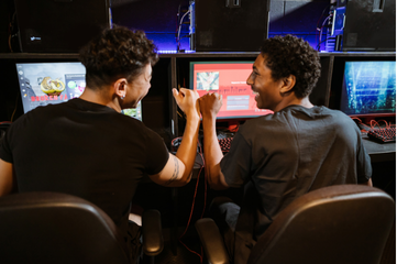 An image of 2 friends celebrate a gaming win